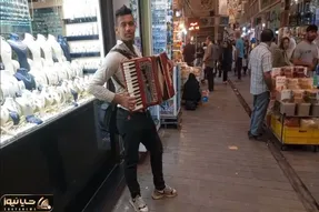 مطربی خیابانی؛ ببینید این پسر با ساز آکاردئونی گوشه بازار چه دلنواز می نوازه