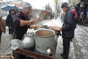 غذای خیابانی؛ ببینید تو برف و سرما کنار جاده چه دیگی بار گذاشتن و کلی هم مشتری اومده